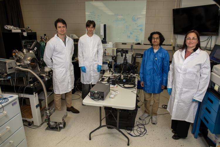 Four GTRI researchers pose for a photo in a lab space. 